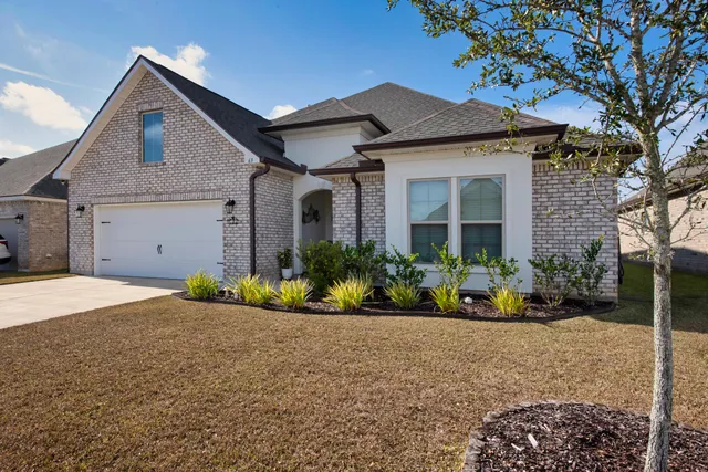 a front view of a house with a garden