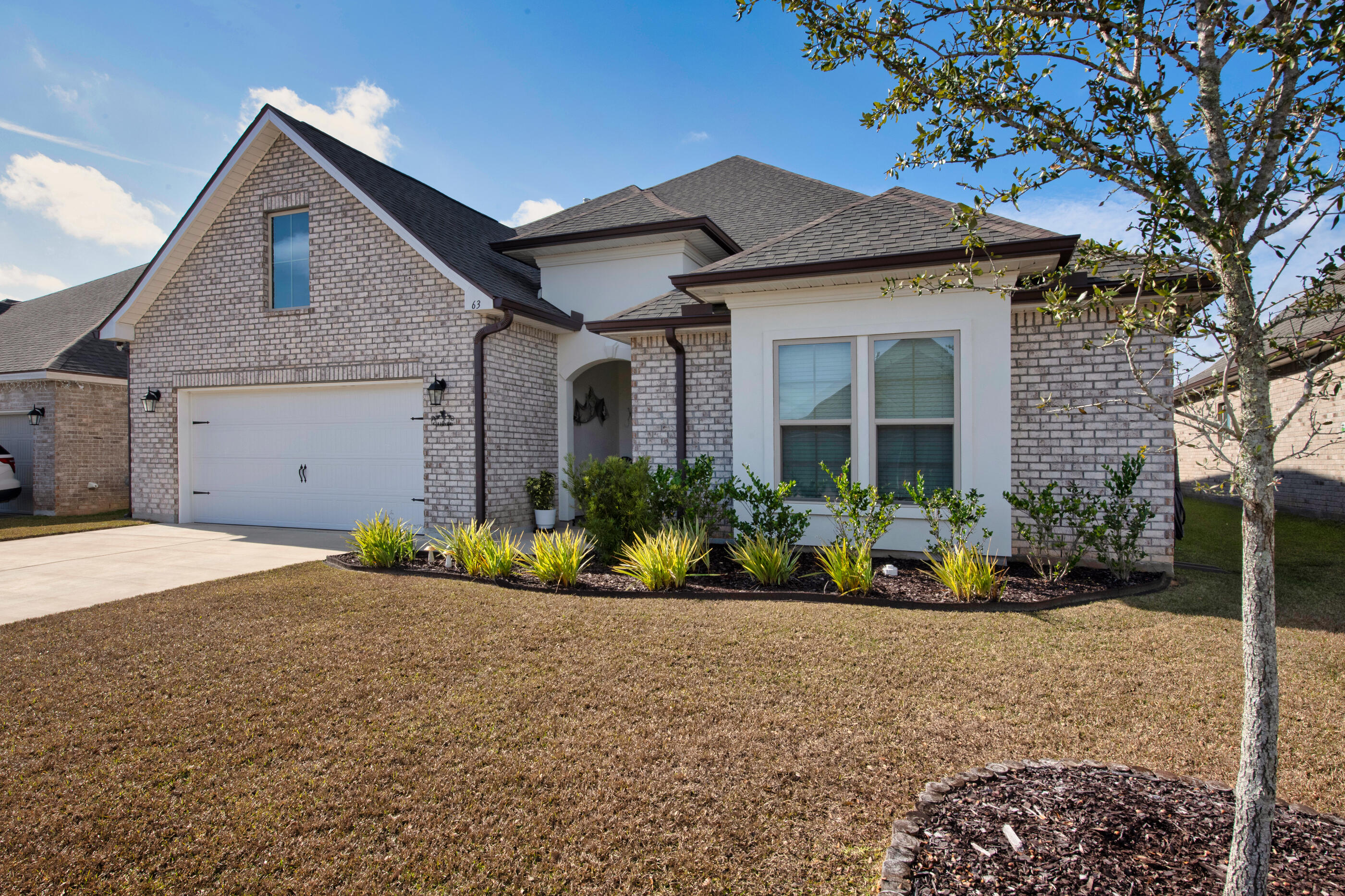 63 Alley Oak Lane Freeport, FL 32439 - Photo 2 of 50 a front view of a house with a garden
