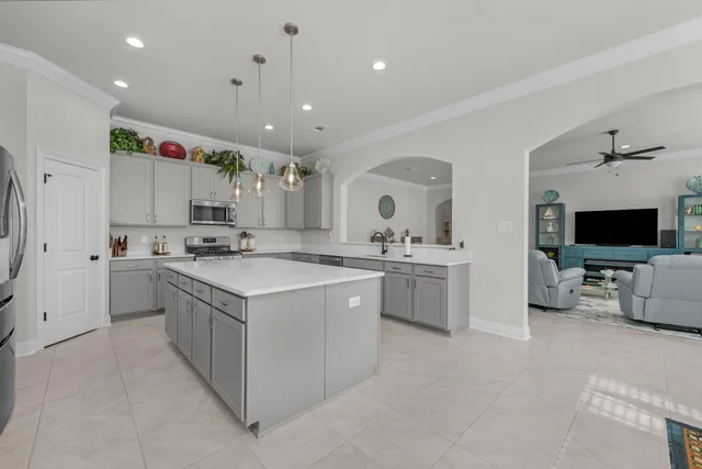 a large kitchen with kitchen island a sink a stove a center island a dining table and chairs