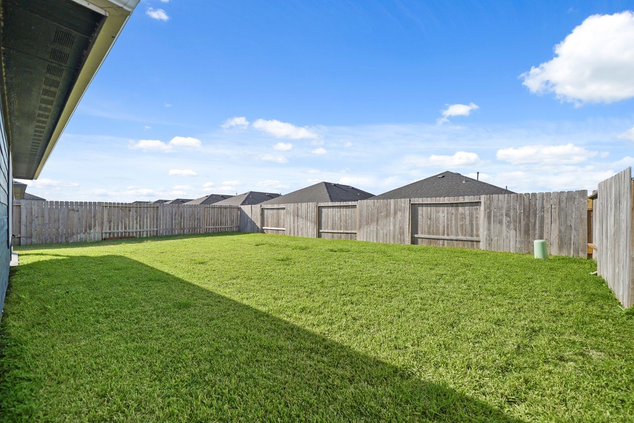7502 Fierce Friesian Lane Rosharon, TX 77583 - Photo 20 of 21 a view of a backyard with table and chairs and wooden fence