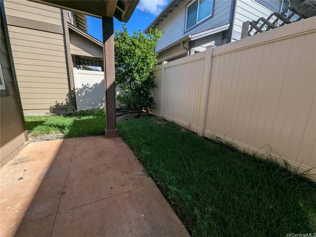 a backyard of a house with plants and barbeque oven