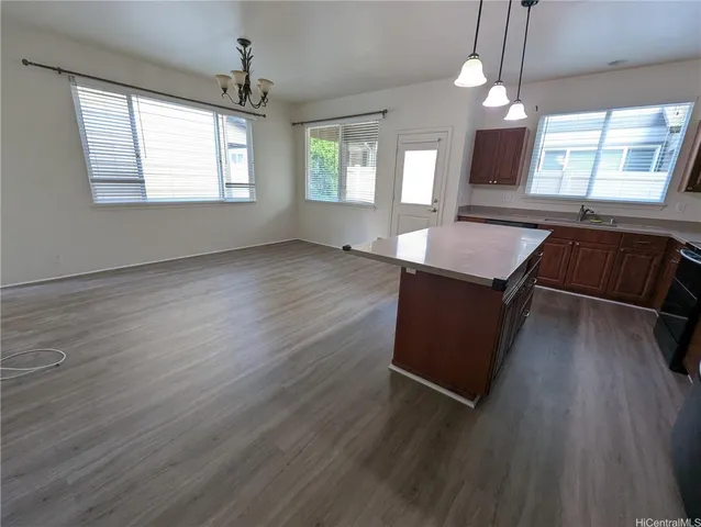 an open kitchen with wooden floor and windows