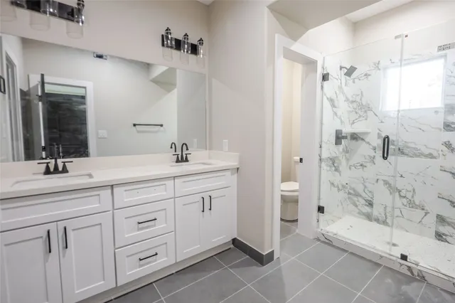 a bathroom with a double vanity sink mirror and shower