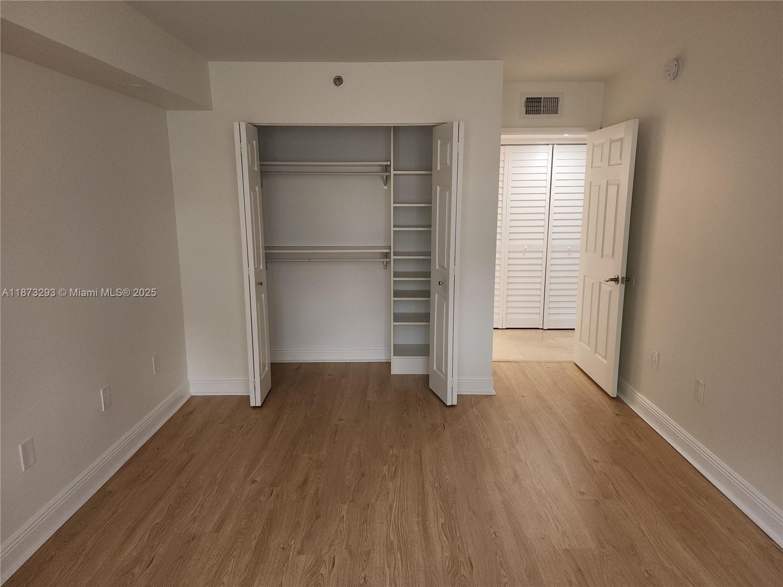 3259 Clint Moore Road, Unit 103 Boca Raton, FL 33496 - Photo 12 of 40 an empty room with wooden floor closet and windows