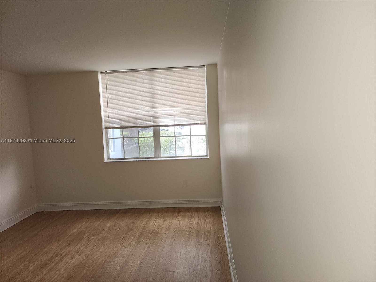 3259 Clint Moore Road, Unit 103 Boca Raton, FL 33496 - Photo 17 of 40 a view of an empty room with wooden floor and a window