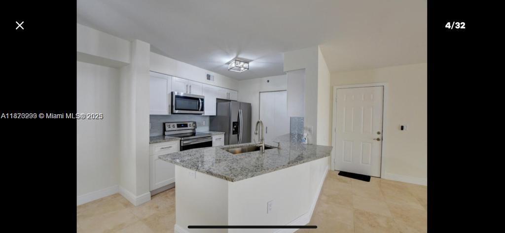 3259 Clint Moore Road, Unit 103 Boca Raton, FL 33496 - Photo 2 of 40 a kitchen with stainless steel appliances granite countertop a sink and refrigerator