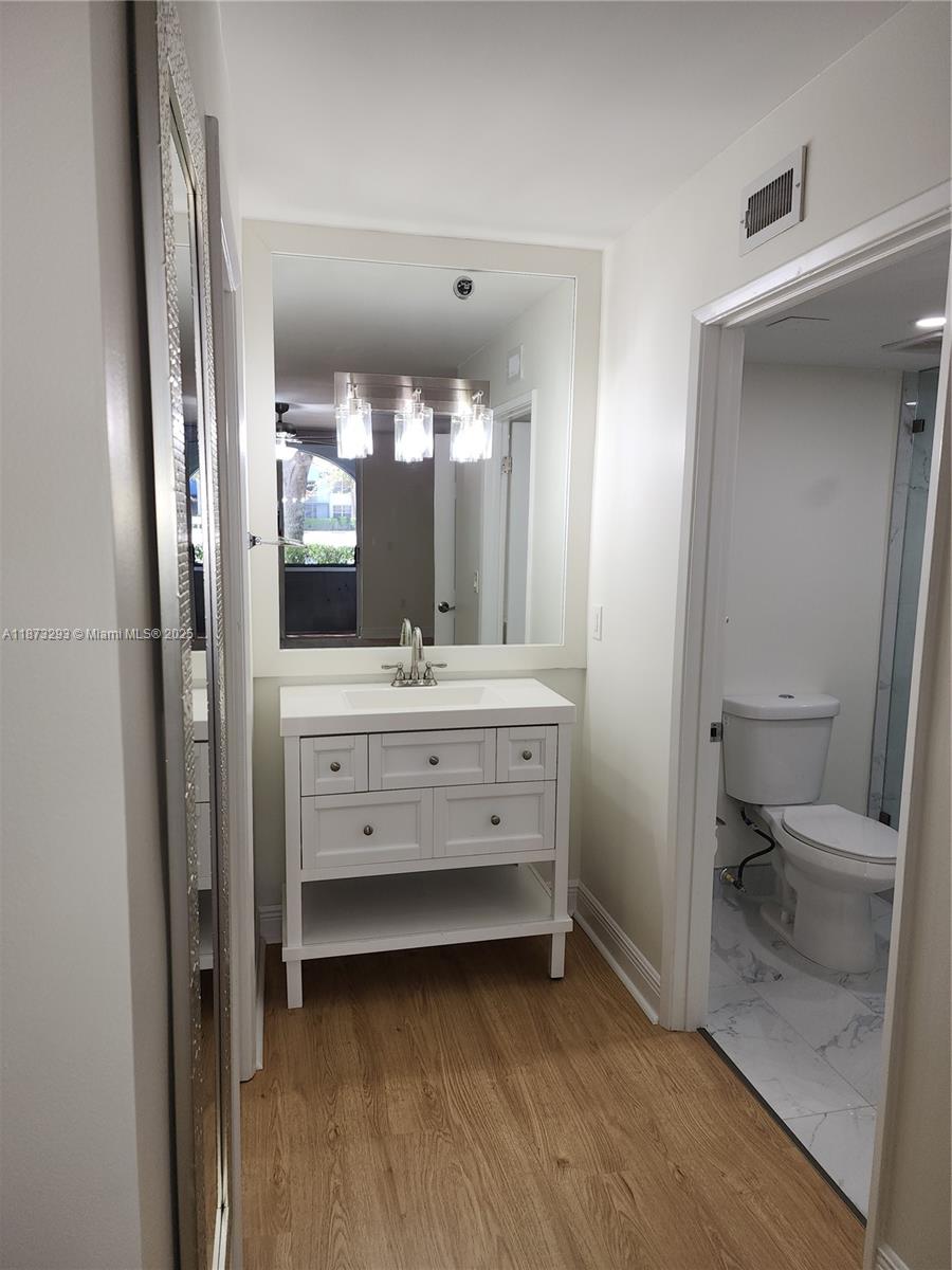 3259 Clint Moore Road, Unit 103 Boca Raton, FL 33496 - Photo 21 of 40 a bathroom with a sink a toilet and a mirror