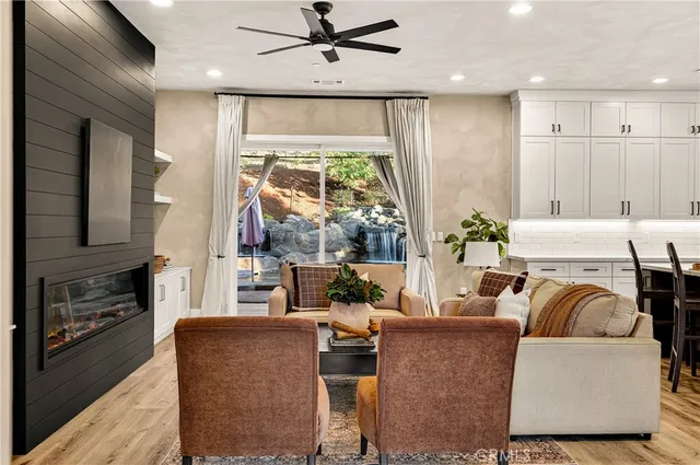 a living room with furniture kitchen view and a chandelier