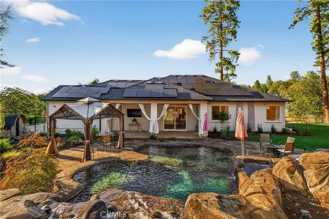 a view of a house with backyard and sitting area