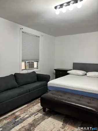 a bedroom with bed couch and window