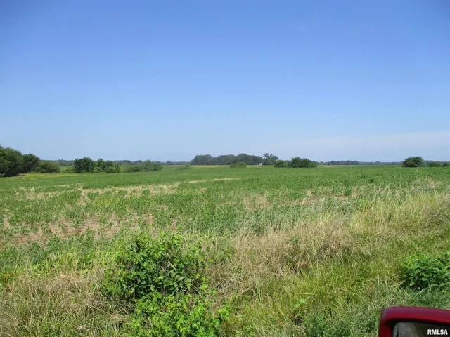 a view of a green field with an ocean view