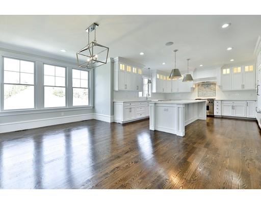 144 Schoolmasters Lane Dedham, MA 02026 - Photo 8 of 29 a view of a kitchen with kitchen island a sink wooden floor and a counter top space