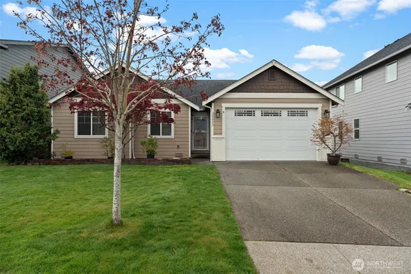 a front view of a house with a garden and yard
