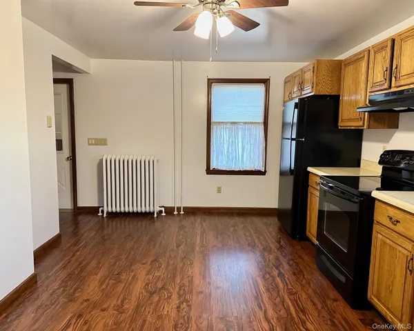a view of a room with wooden floor and a fireplace