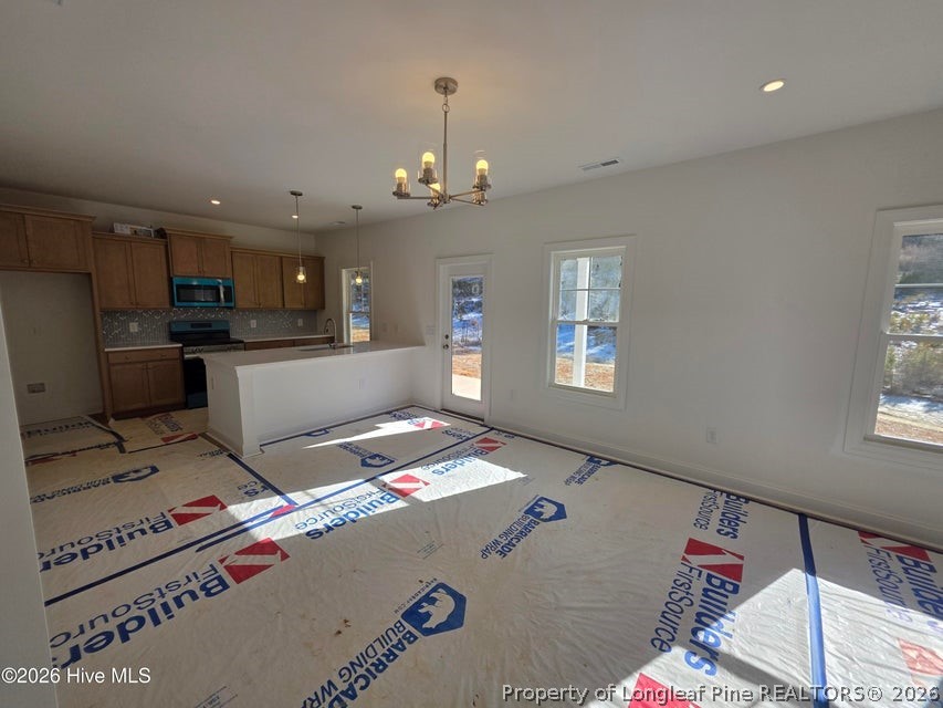 142 Carver Street Carthage, NC 28327 - Photo 2 of 40 a living room with kitchen island furniture and a chandelier