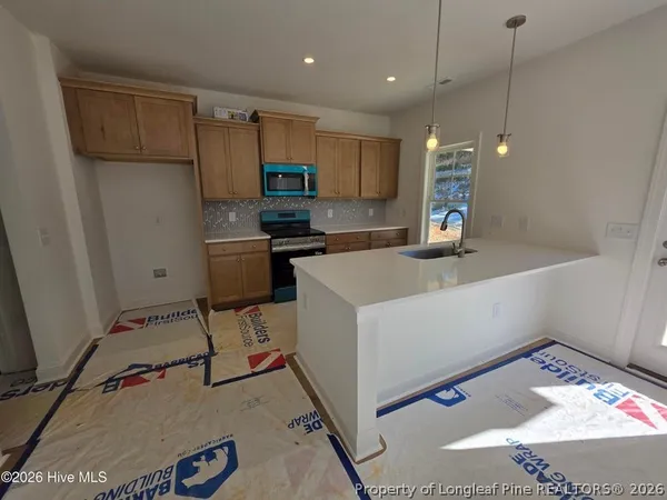 a kitchen that has a sink window and stainless steel appliances