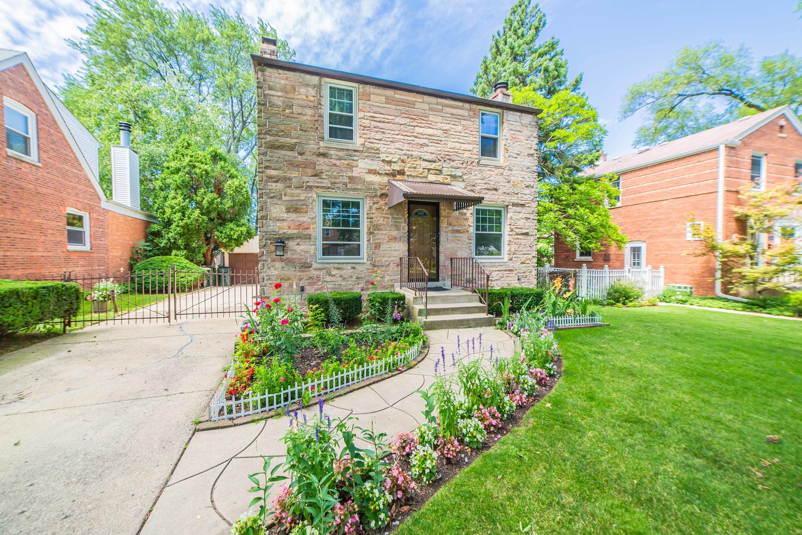 a front view of a house with a yard and potted plants