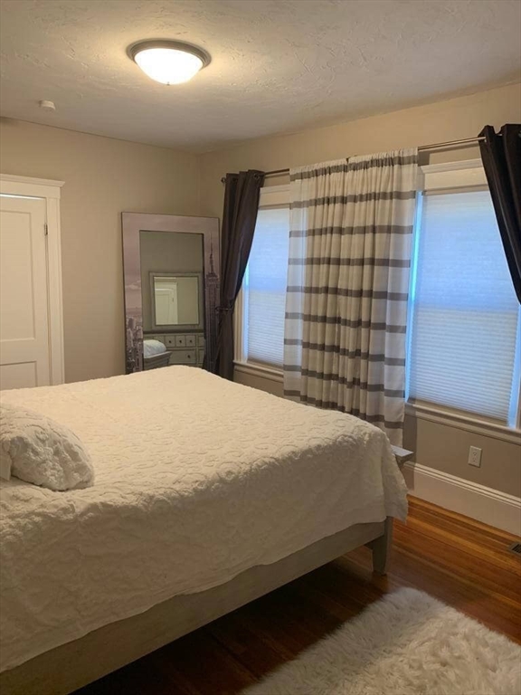 348 School Street, Unit 348 Watertown, MA 02472 - Photo 14 of 15 a bedroom with a bed and painting on the wall