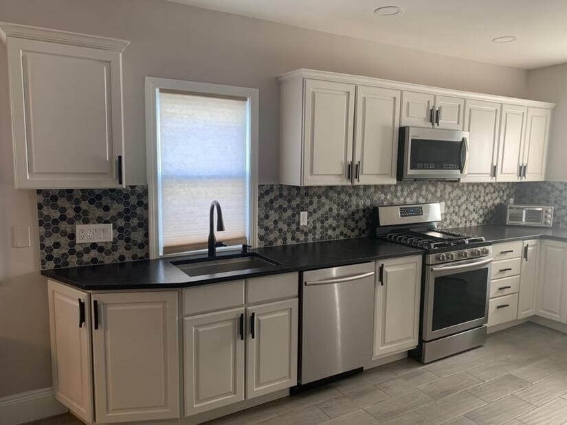 348 School Street, Unit 348 Watertown, MA 02472 - Photo 7 of 15 a kitchen with white cabinets sink and stainless steel appliances