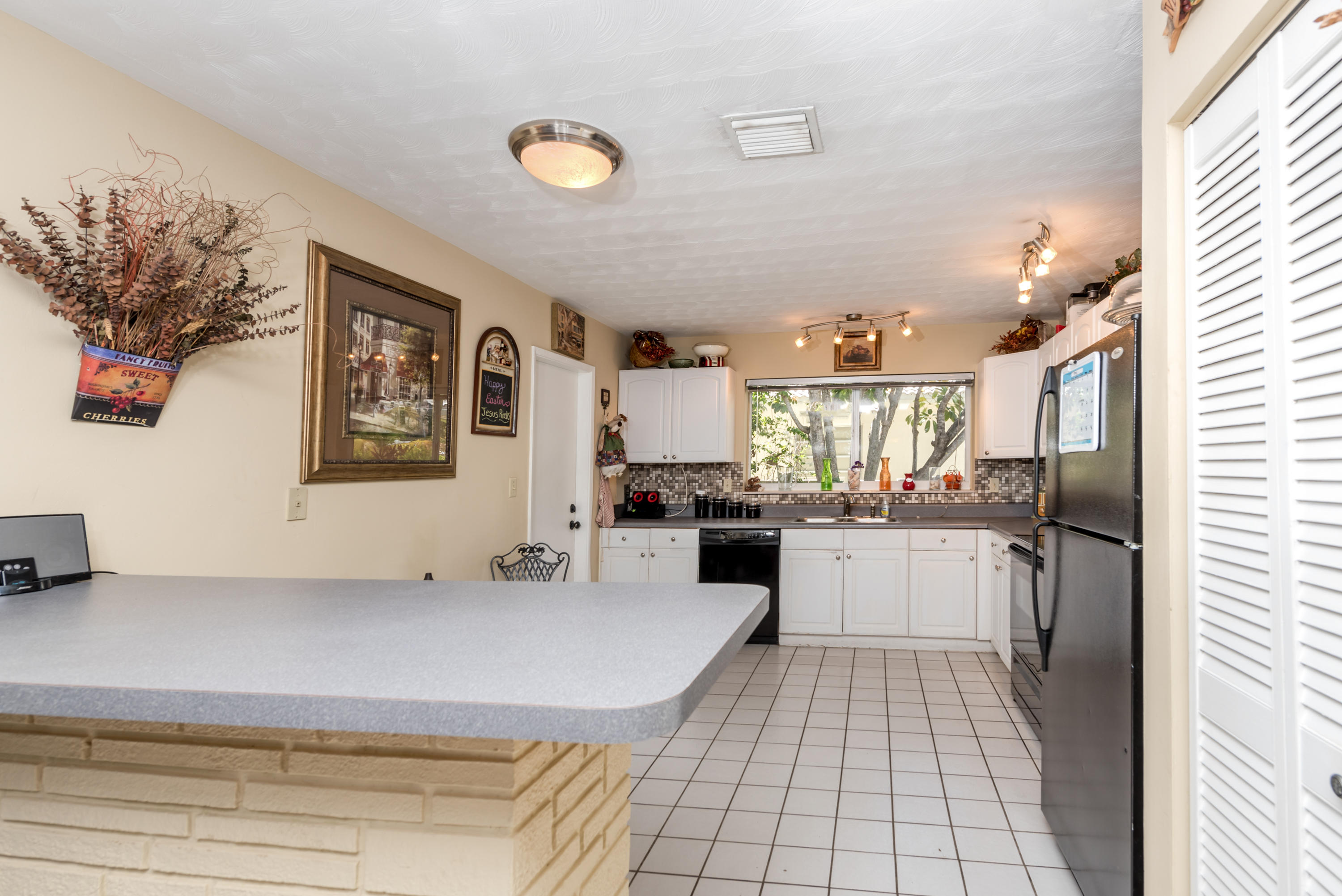 455 Northeast 37th Street Boca Raton, FL 33431 - Photo 5 of 19 a kitchen with granite countertop a sink stove and cabinets