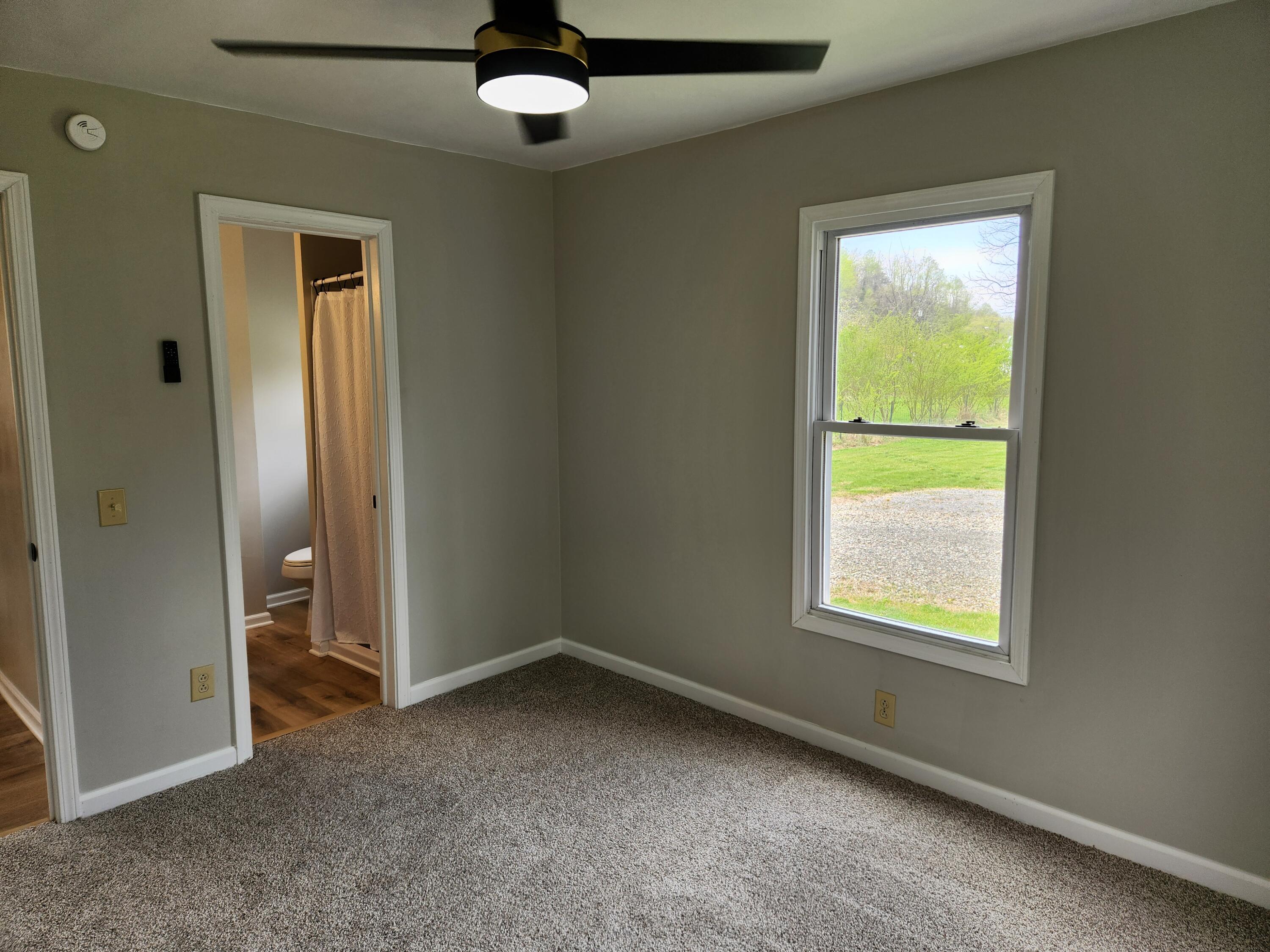 101 Union Road Ferrum, VA 24088 - Photo 20 of 41 an empty room with a window and a fan