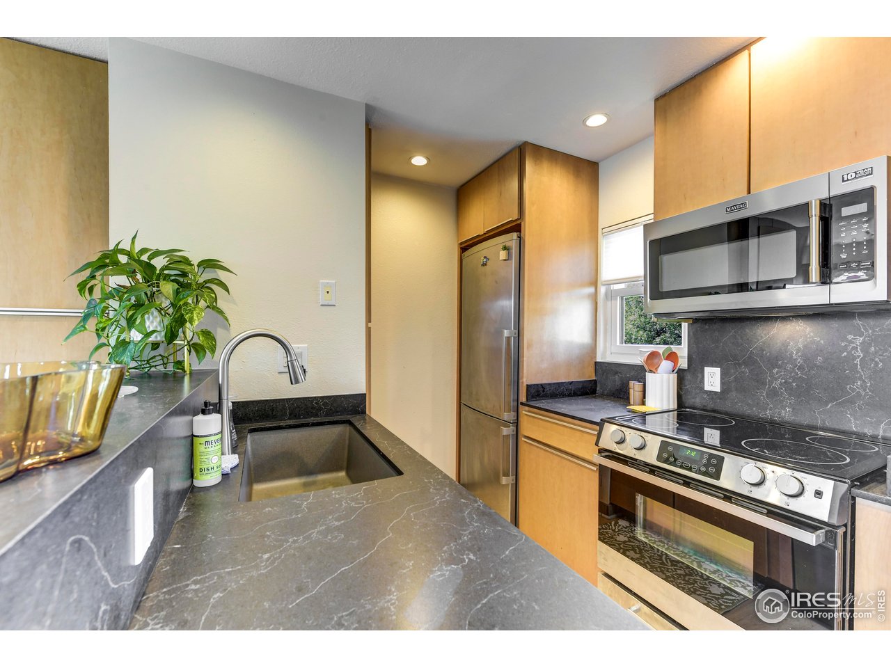 3025 Broadway, Unit 10 Boulder, CO 80304 - Photo 8 of 20 a kitchen with stainless steel appliances a sink a stove top oven a counter space and cabinets