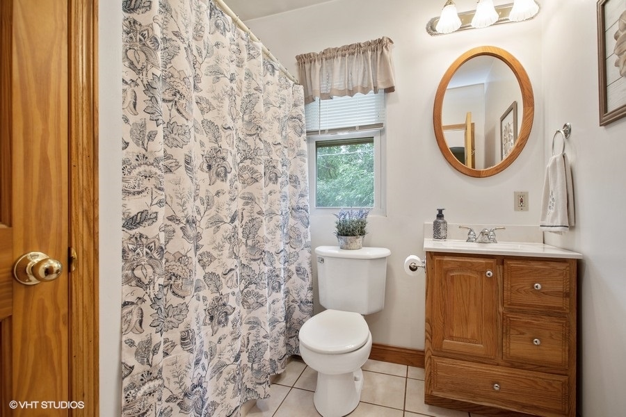 8808 Bard Road Crystal Lake, IL 60014 - Photo 19 of 32 a bathroom with a granite countertop toilet and a sink