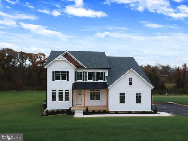 a view of a house with a yard and pathway