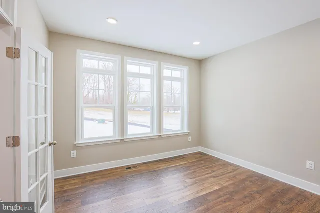 a kitchen that has a lot of cabinets in it and wooden floors