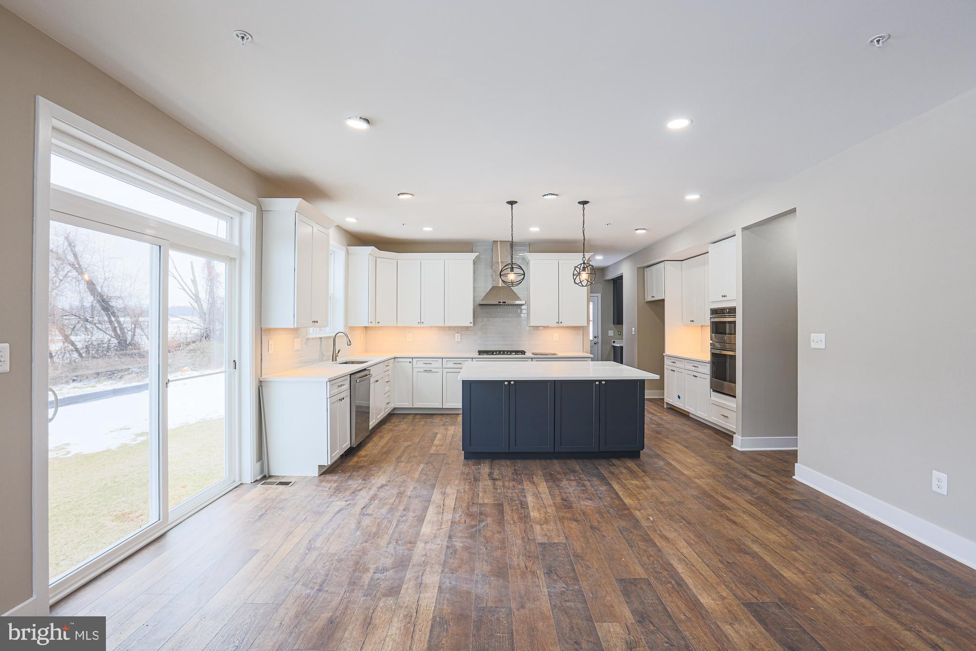 4712 Carroll Manor Road Baldwin, MD 21013 - Photo 19 of 69 a large kitchen with stainless steel appliances kitchen island a large counter top and a wooden floors