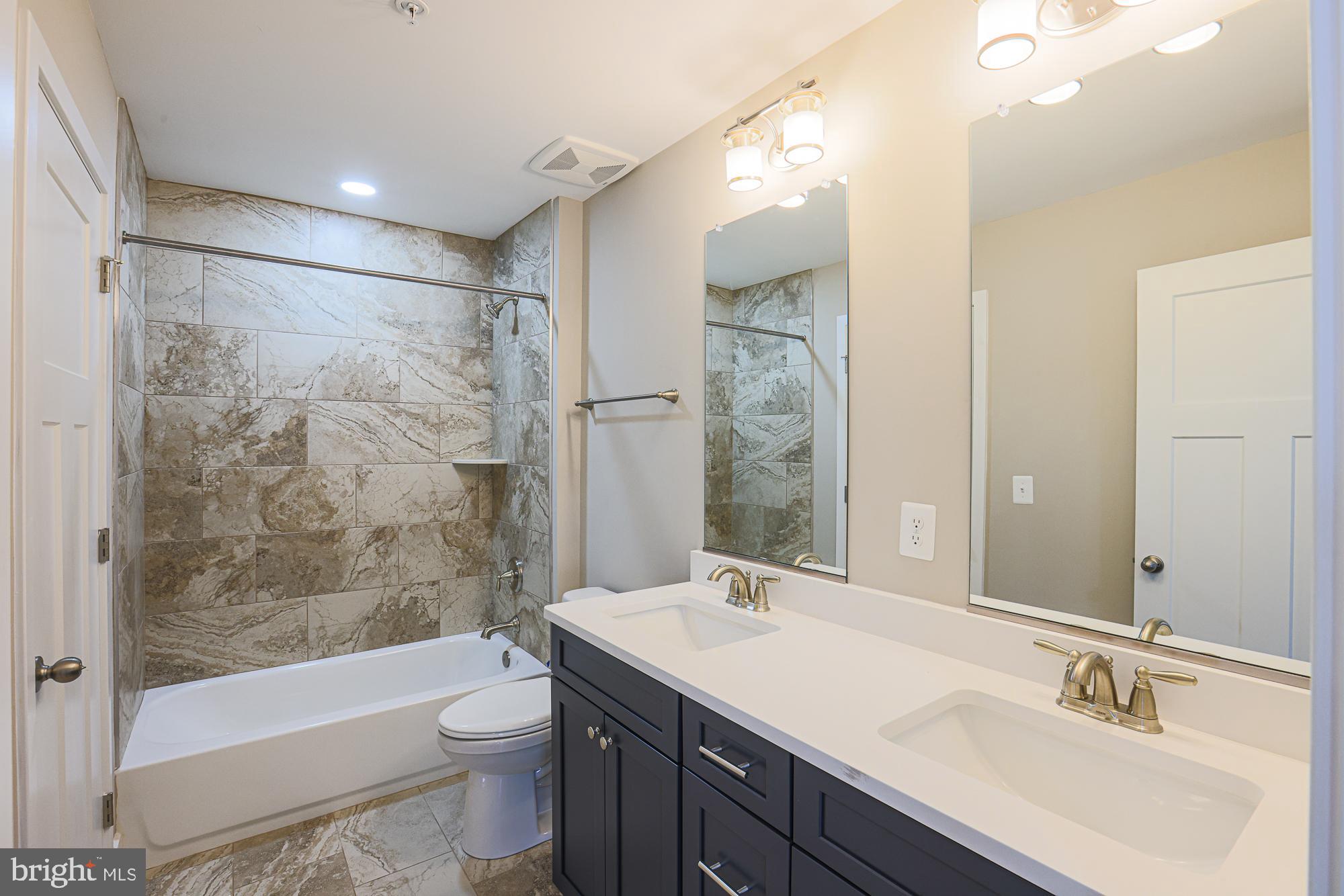 4712 Carroll Manor Road Baldwin, MD 21013 - Photo 41 of 69 a bathroom with a bathtub shower sink mirror and toilet