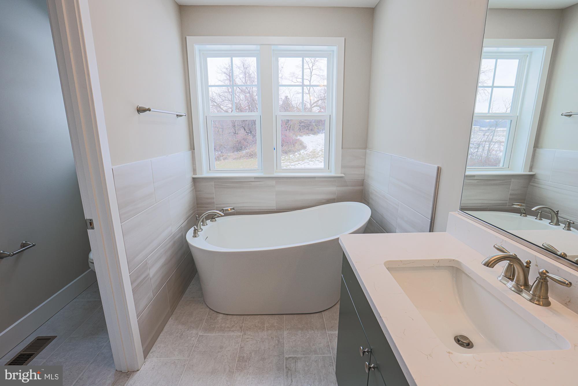 4712 Carroll Manor Road Baldwin, MD 21013 - Photo 54 of 69 a bathroom with a tub a sink and a window