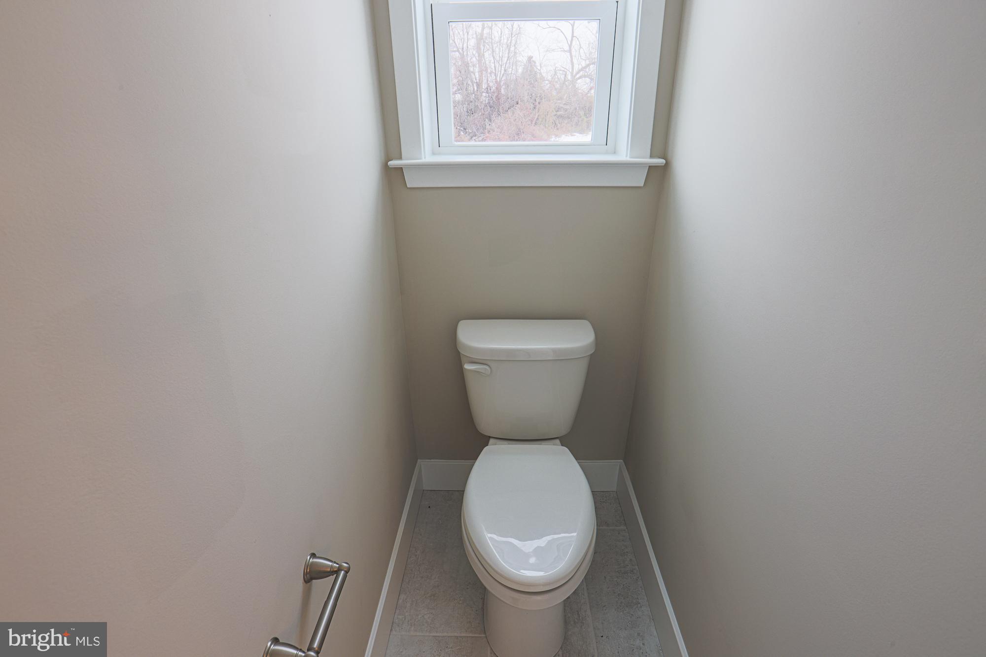 4712 Carroll Manor Road Baldwin, MD 21013 - Photo 56 of 69 a white toilet sitting in a bathroom next to a window