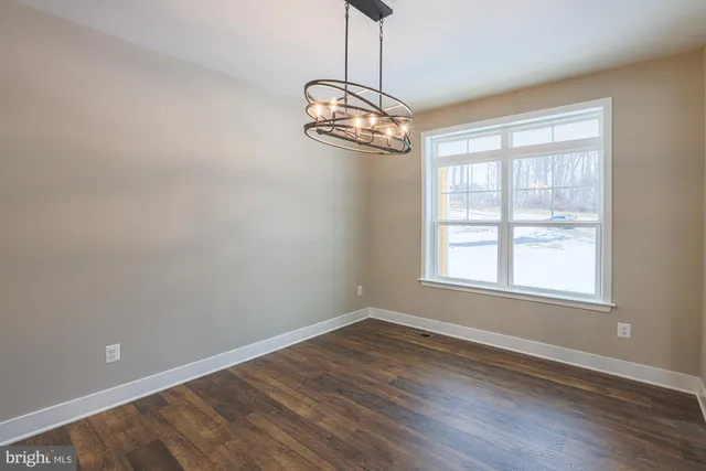 a big room with wooden floor an outdoor space and windows