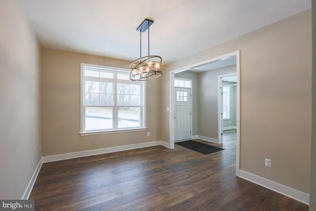 a large kitchen with stainless steel appliances kitchen island a large counter top and a wooden floors