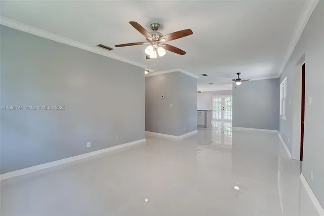 a view of an empty room with a ceiling fan and window