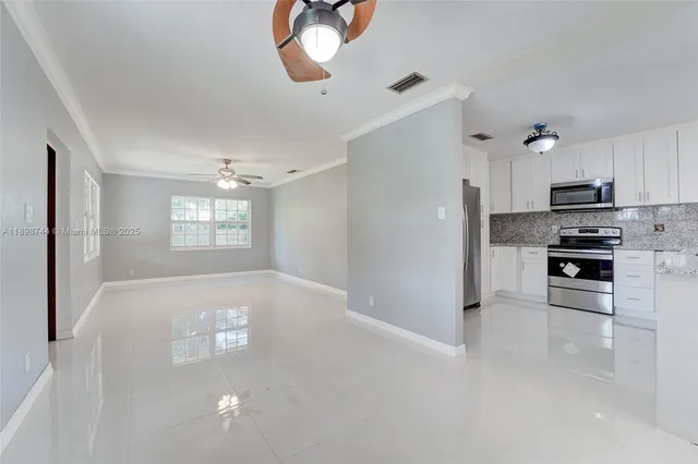 a kitchen with kitchen island white cabinets stainless steel appliances and window