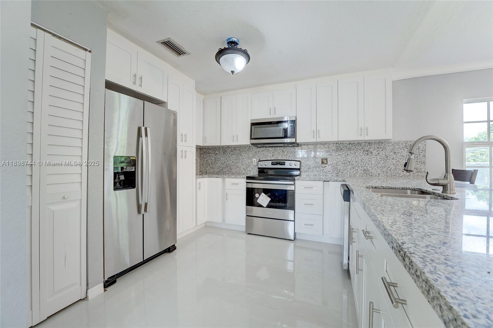 5130 Southwest 208th Lane Southwest Ranches, FL 33332 - Photo 15 of 53 a kitchen with kitchen island a sink stainless steel appliances and cabinets