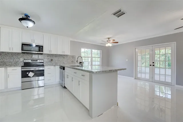 a kitchen with stainless steel appliances a sink stove and cabinets