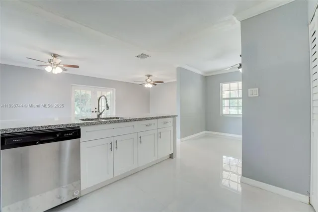 a kitchen with granite countertop white cabinets and white appliances