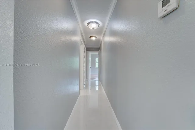 an empty room with windows and ceiling fan