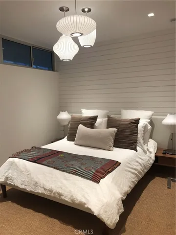 a bedroom with bed and a chandelier