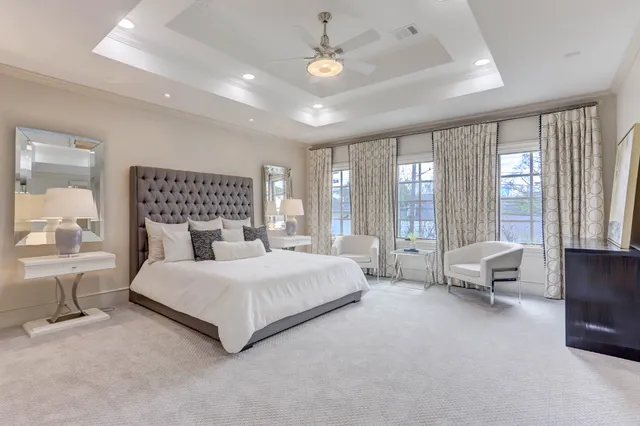 a bedroom with a bed couch and large window