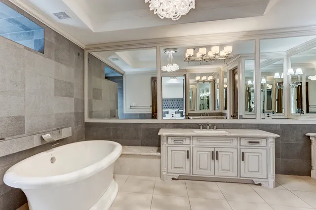 a bathroom with a tub sink shower and a mirror