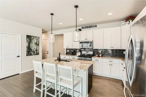 a kitchen with sink table and chairs