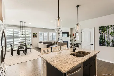 a kitchen with a stove top oven a sink a dining table and chairs