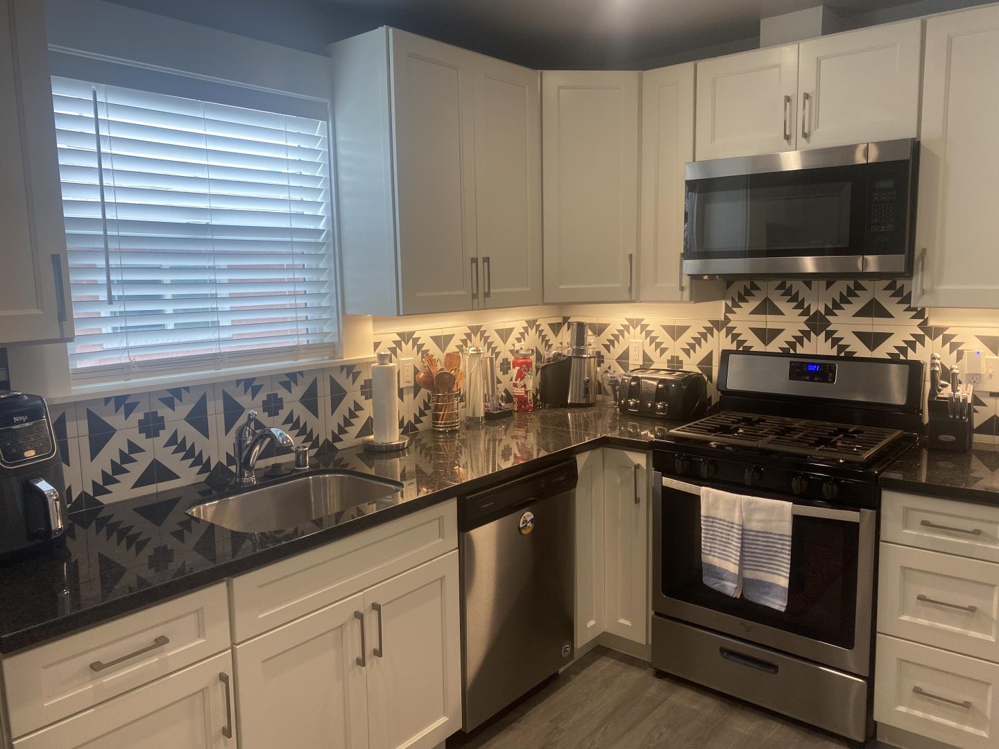 1132 85th Avenue Oakland, CA 94621 - Photo 11 of 28 a kitchen with granite countertop a stove and a sink