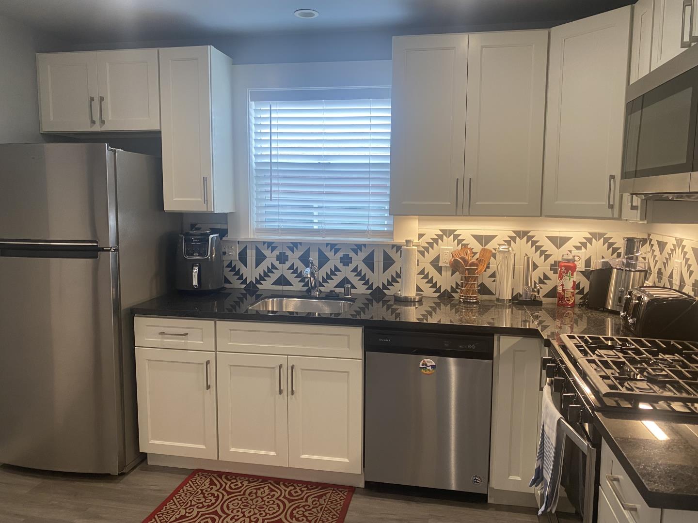 1132 85th Avenue Oakland, CA 94621 - Photo 13 of 28 a kitchen with granite countertop a sink stove and refrigerator