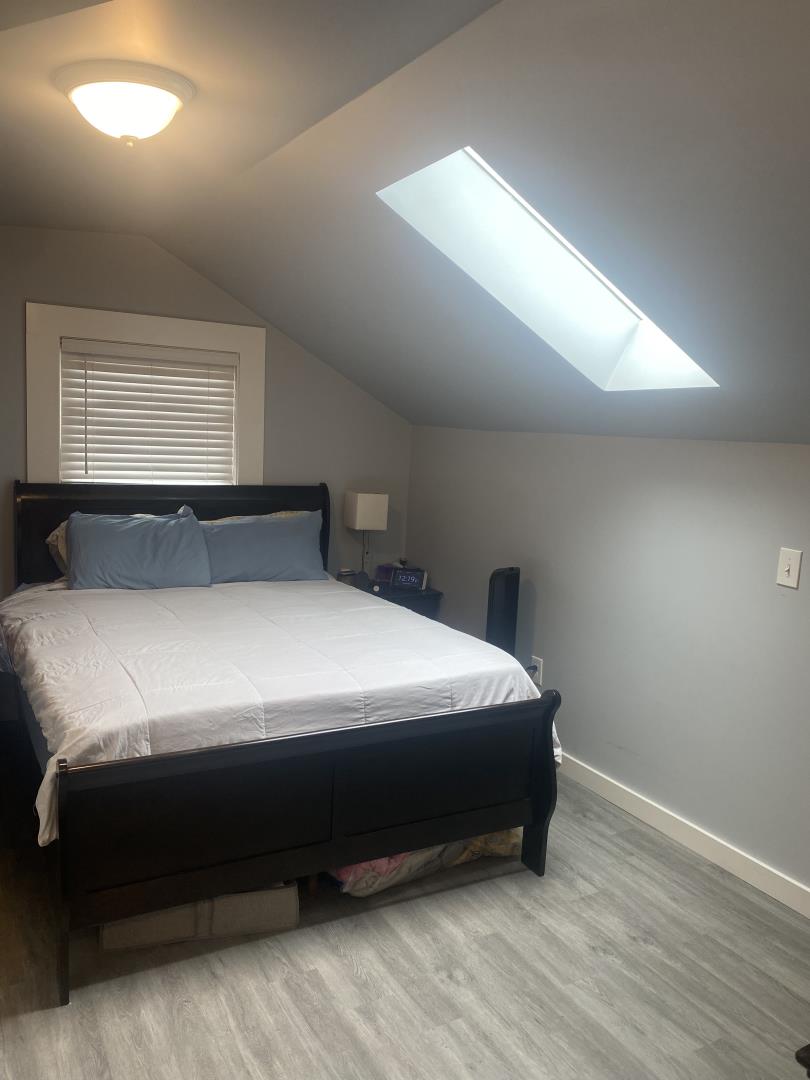 1132 85th Avenue Oakland, CA 94621 - Photo 21 of 28 a bedroom with a bed and window