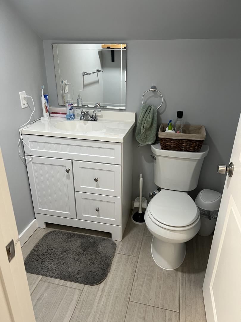 1132 85th Avenue Oakland, CA 94621 - Photo 22 of 28 a bathroom with a granite countertop toilet and a sink